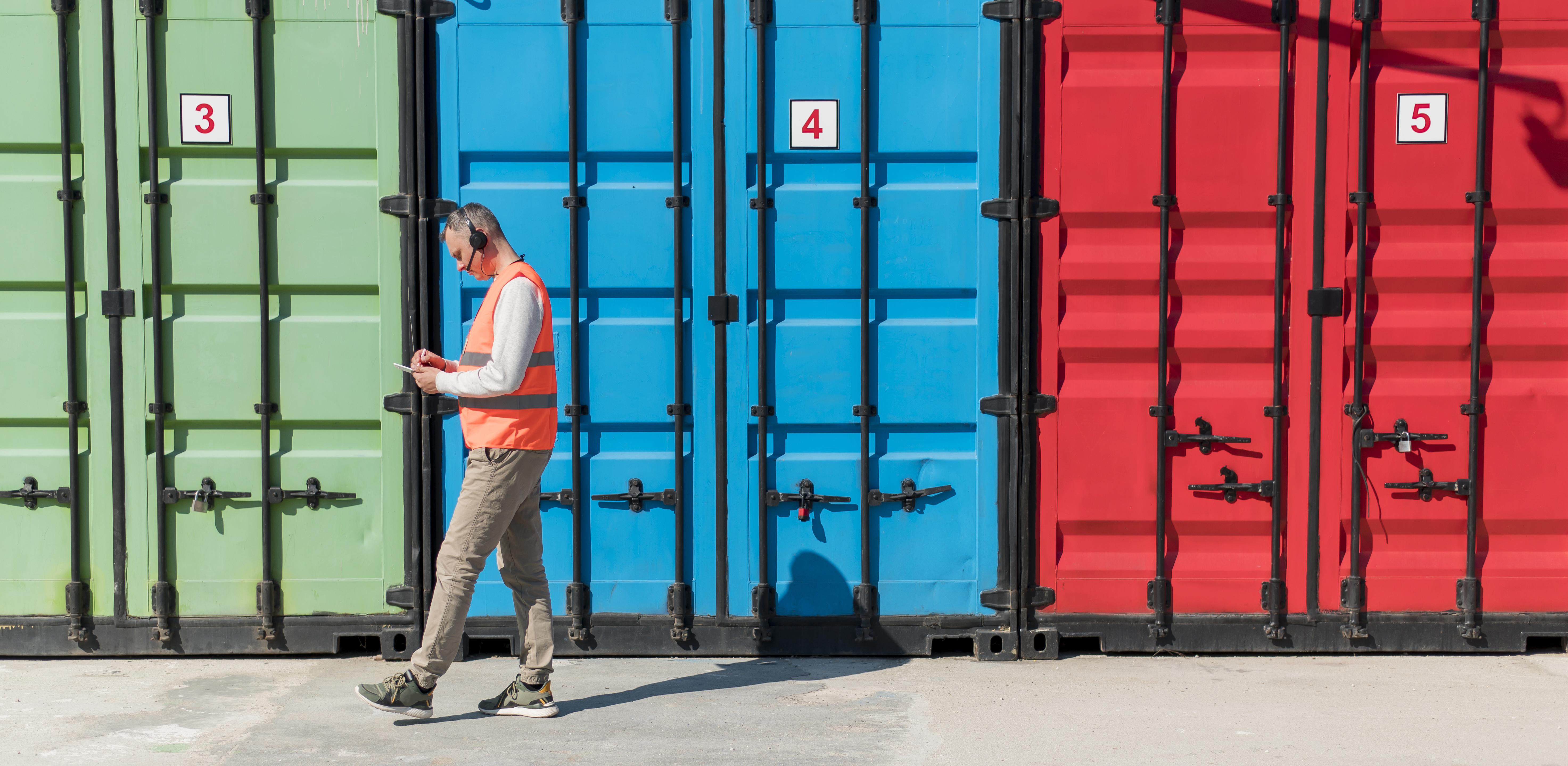 Worker inspecting containers at yard